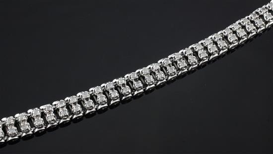 A 9ct white gold and diamond line bracelet, 7in.